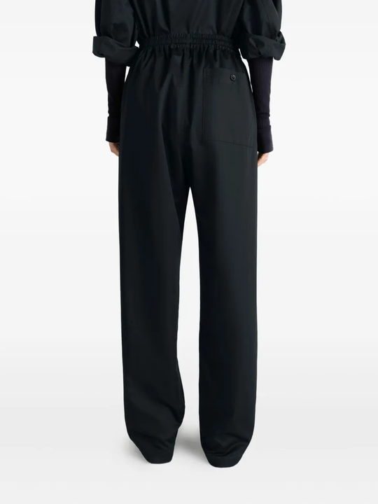 black pants worn by a person, showing the pants fit