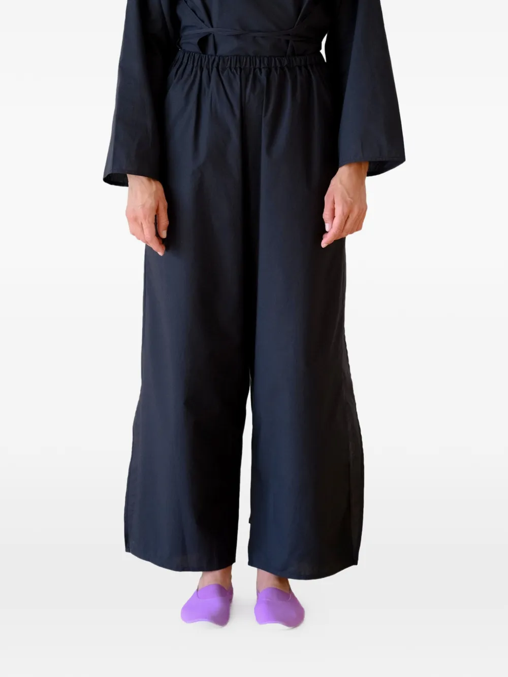 Black pants worn by a person, showing the pants's fit