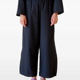 Black pants worn by a person, showing the pants's fit