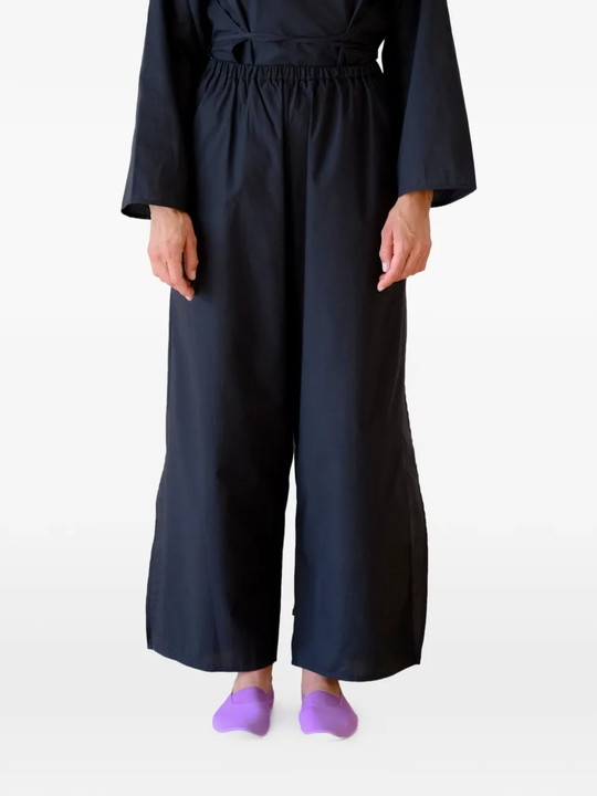 Black pants worn by a person, showing the pants's fit