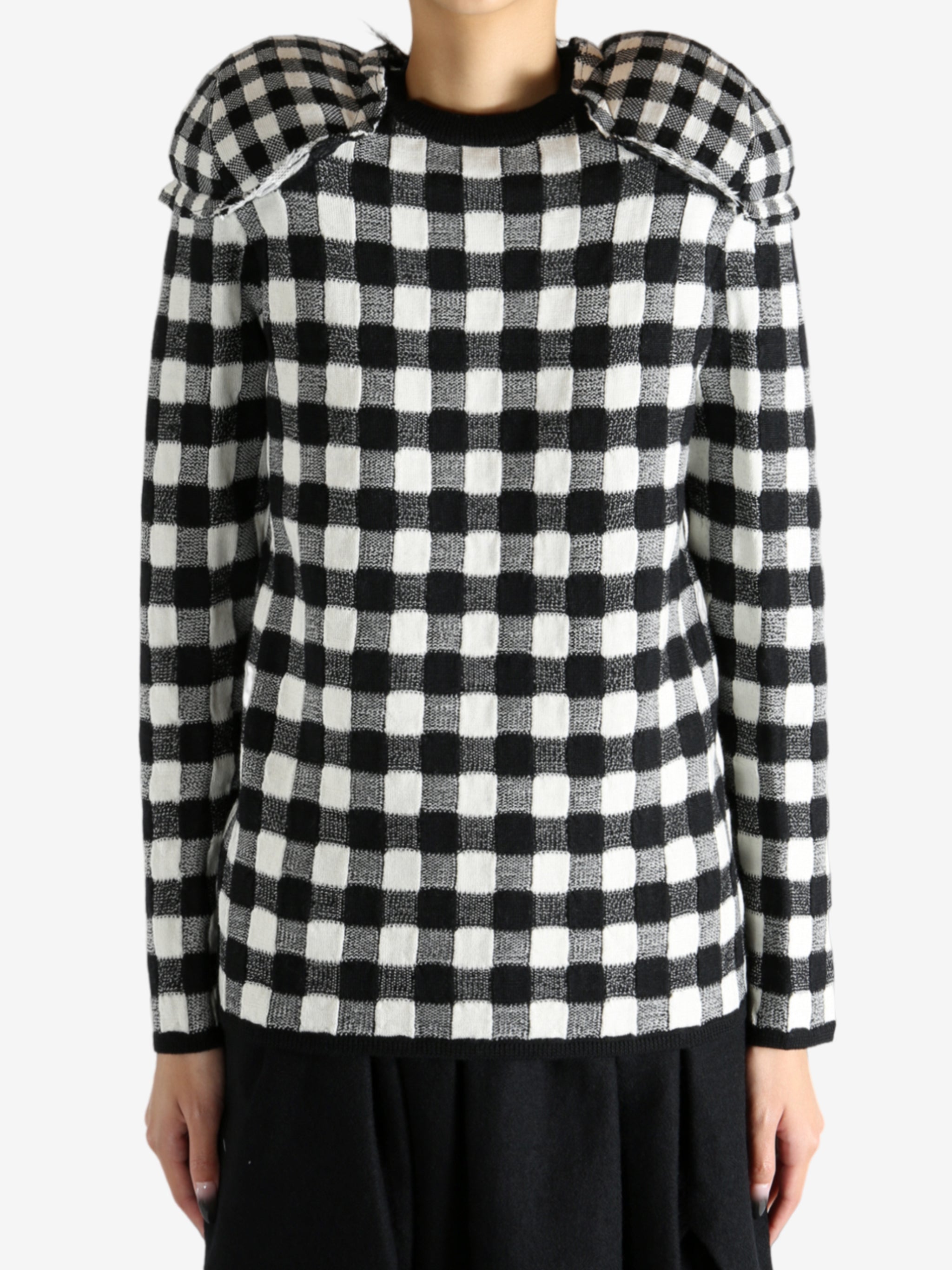 Black sweater worn by a person, showing the knitwear's fit