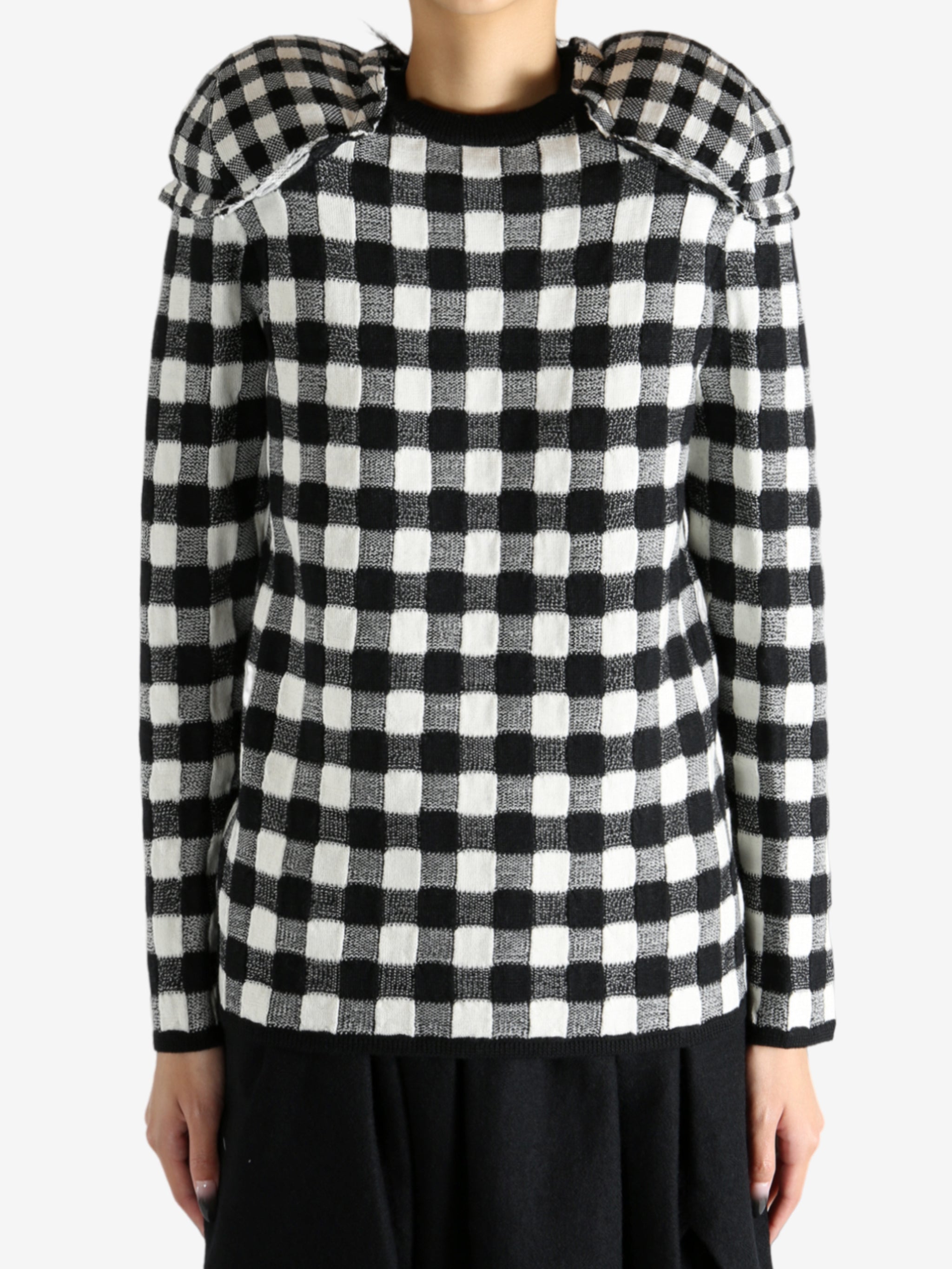 Black sweater worn by a person, showing the knitwear's fit