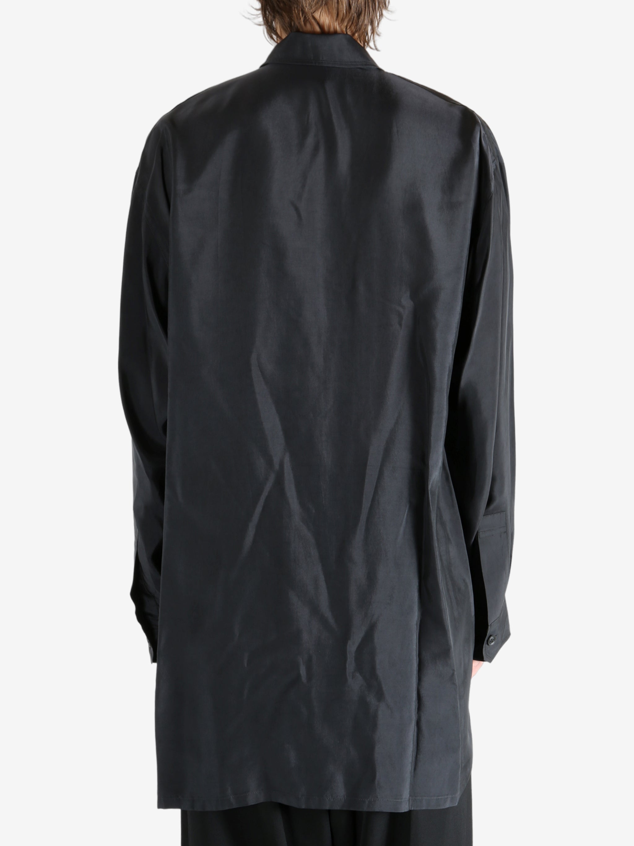 Black shirt worn by a person, showing the shirt's fit