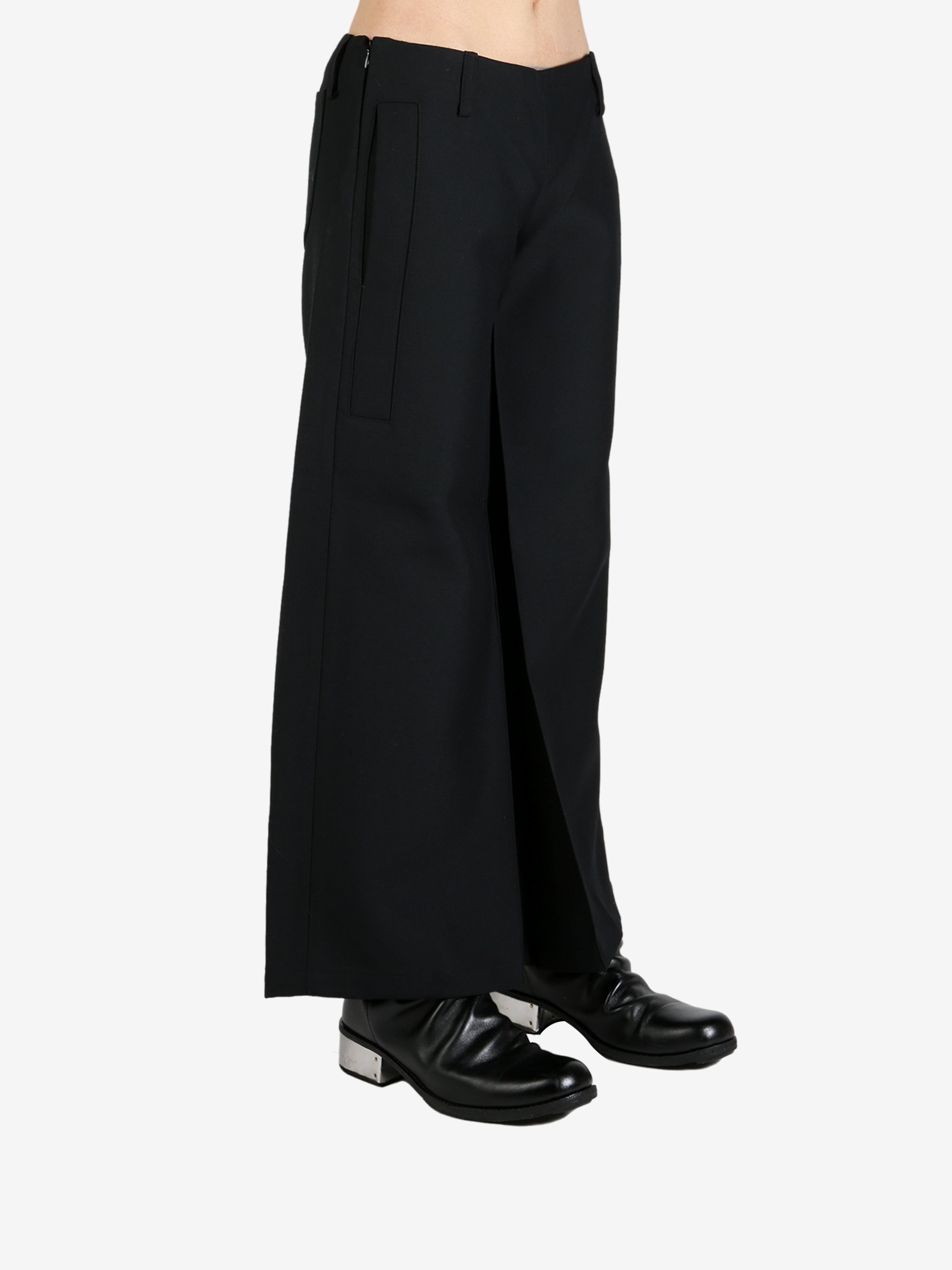Black pants worn by a person, showing the pants's fit