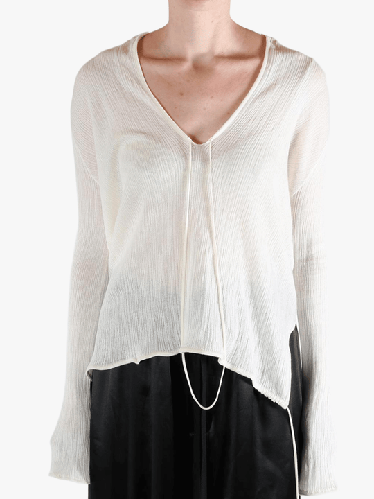 White sweater worn by a person, showing the sweater's fit