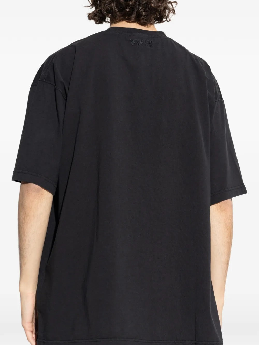 Black t-shirts worn by a person, showing the t-shirts fit