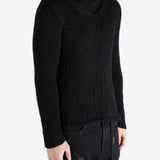 Black sweater worn by a person, showing the sweater's fit