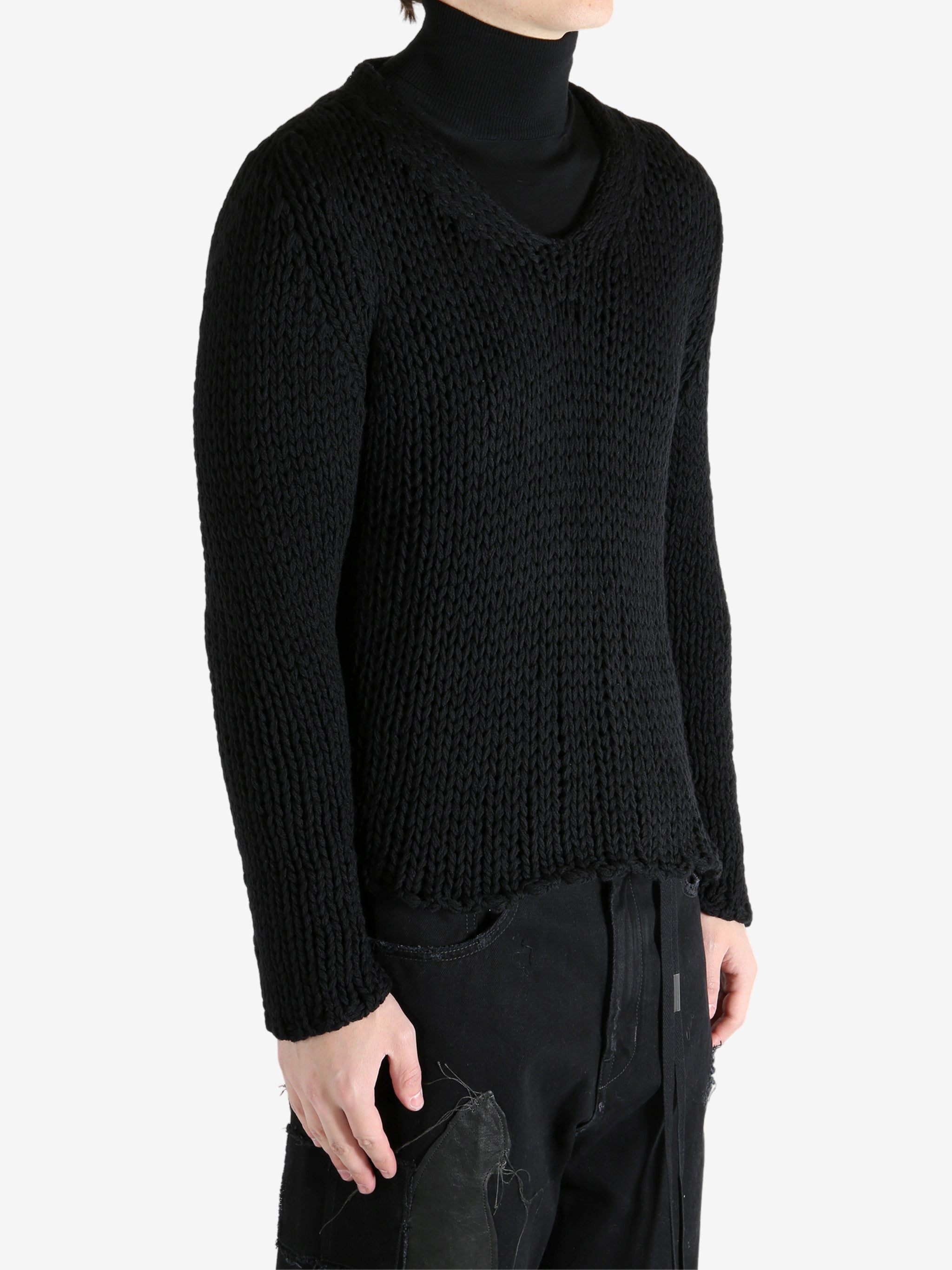 Black sweater worn by a person, showing the sweater's fit