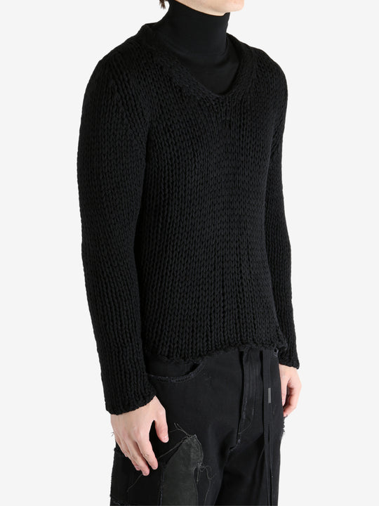 Black sweater worn by a person, showing the sweater's fit