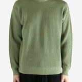 Green knitwear worn by a person, showing the knitwear's fit