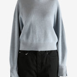 Blue knitwear worn by a person, showing the knitwear's fit