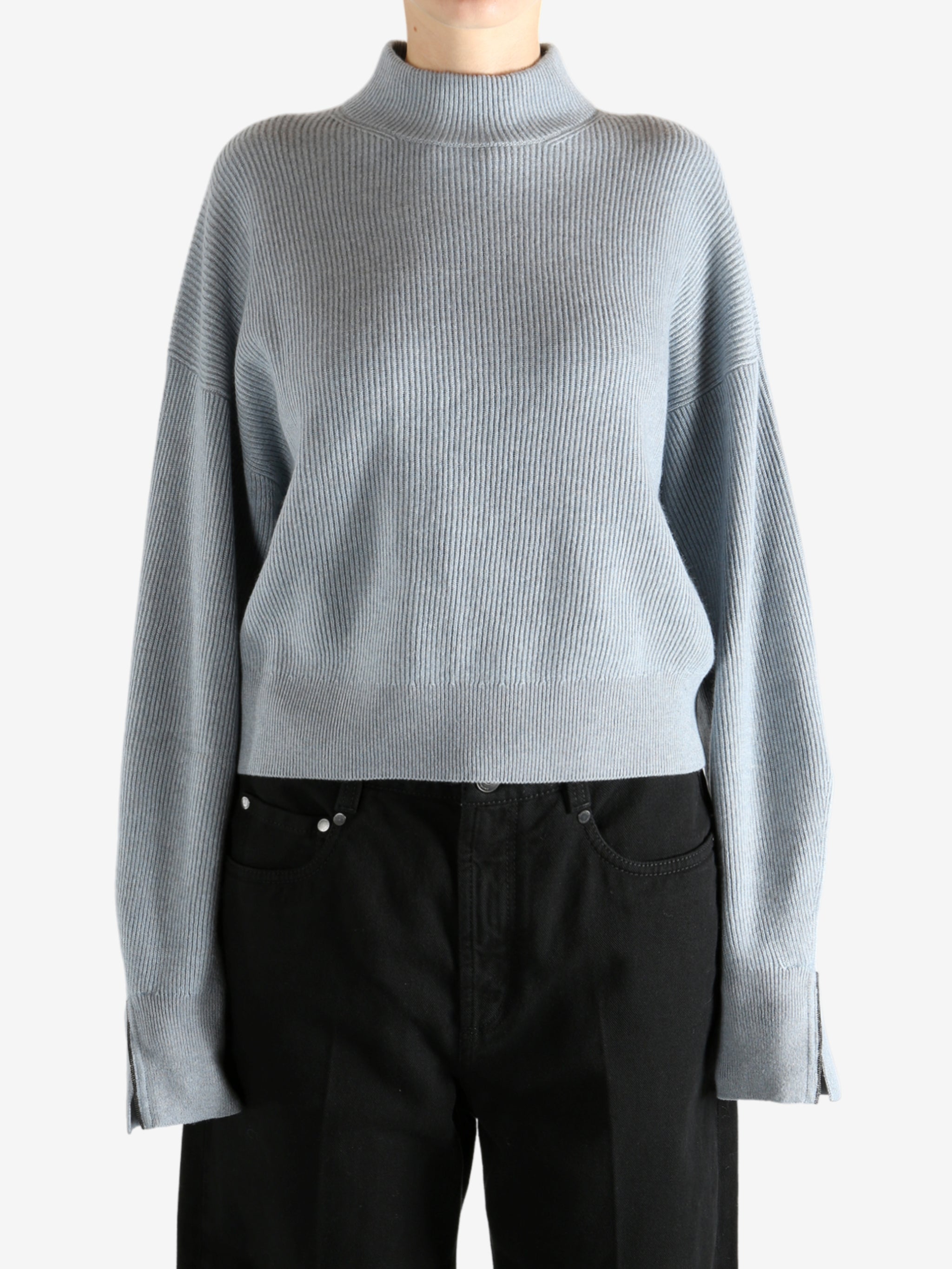 Blue knitwear worn by a person, showing the knitwear's fit