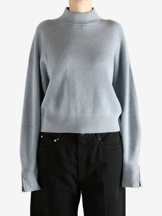 Blue knitwear worn by a person, showing the knitwear's fit