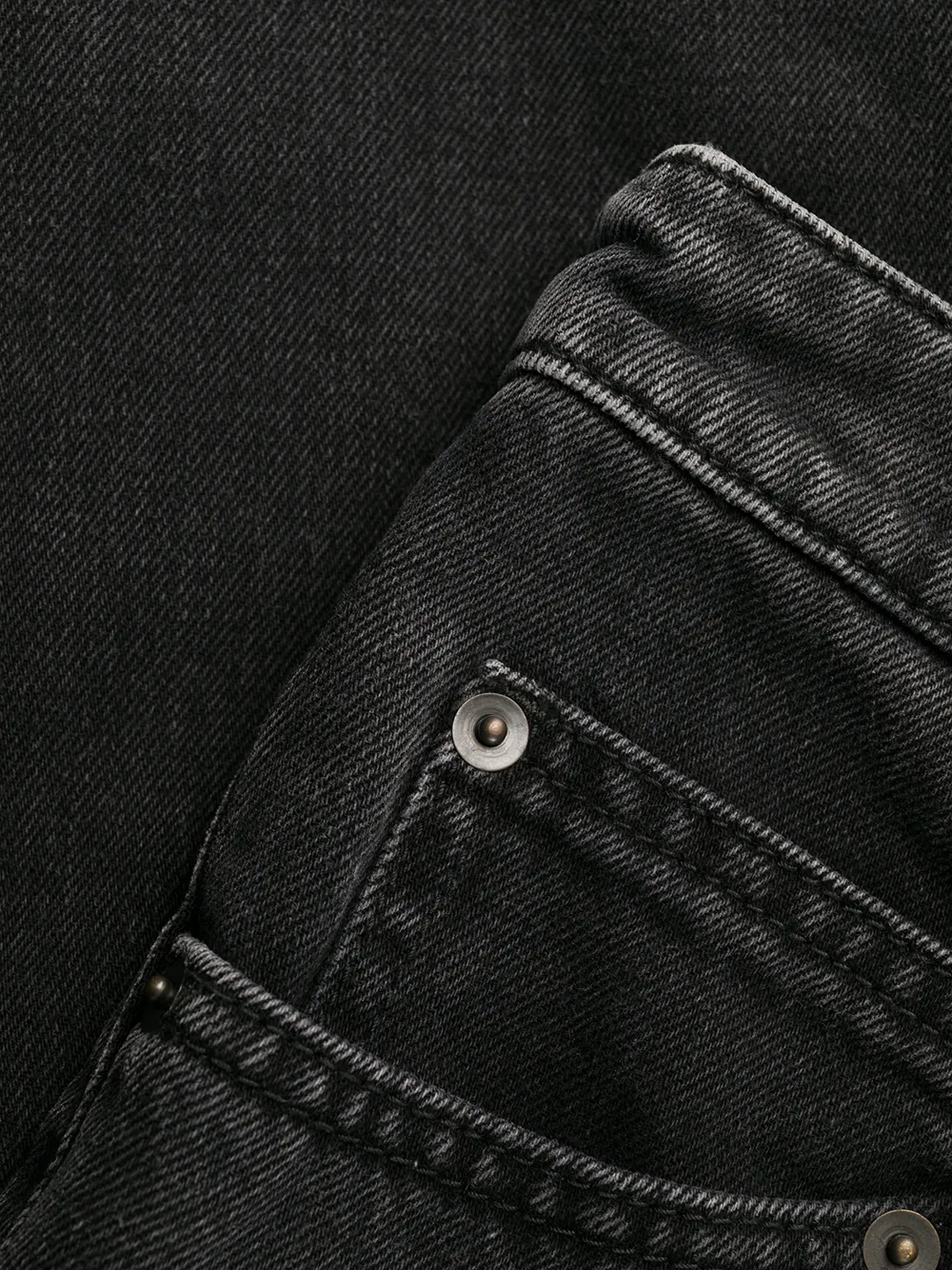 Close up of black pants, showing texture of the Denim fabric
