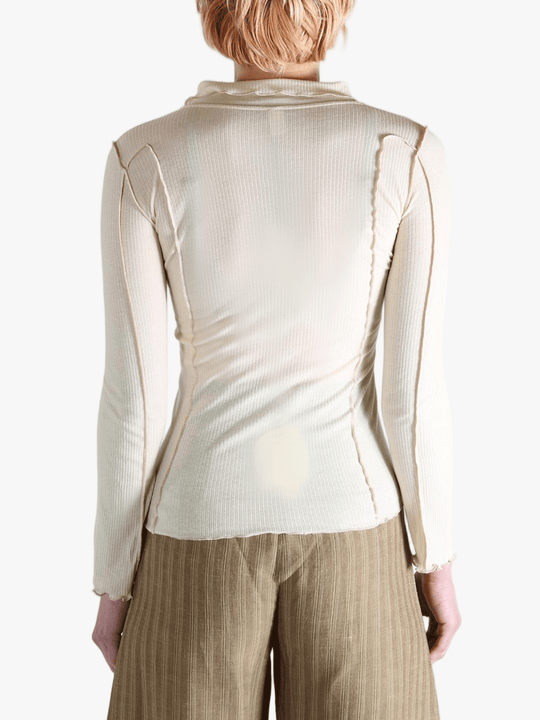 White top worn by a person,showing the top fit