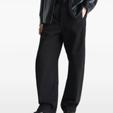 Black sneakers worn by a person, showing the sneaker's fit