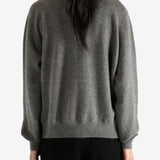 Grey knitwear worn by a person, showing the knitwear's fit