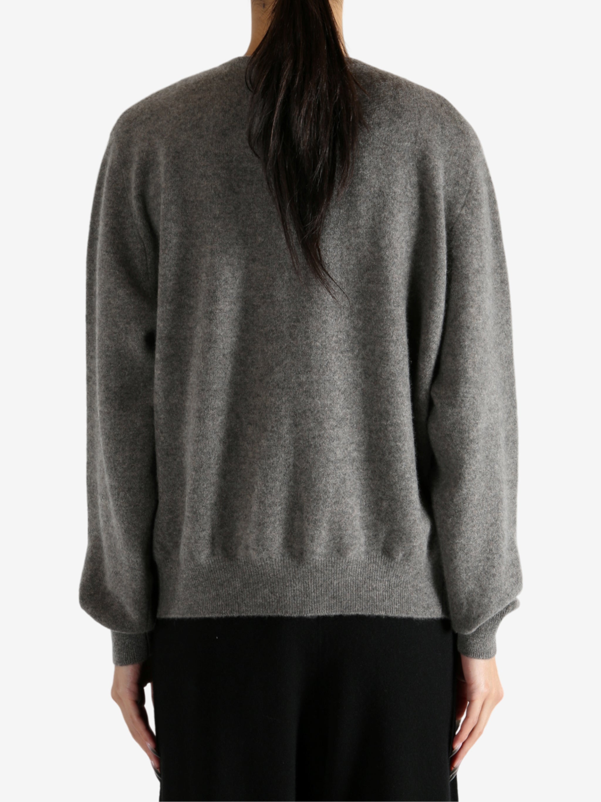 Grey knitwear worn by a person, showing the knitwear's fit