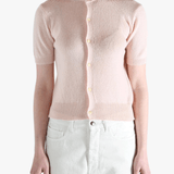 Pink knitwear worn by a person, showing the knitwear's fit