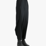 Black pants worn by a person, showing the pants's fit