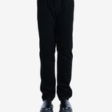 Black pants worn by a person, showing the pants's fit