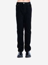 Black pants worn by a person, showing the pants's fit