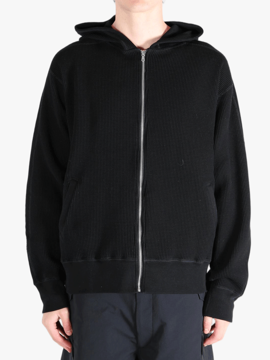 Black hoodie worn by a person, showing the hoodie's fit