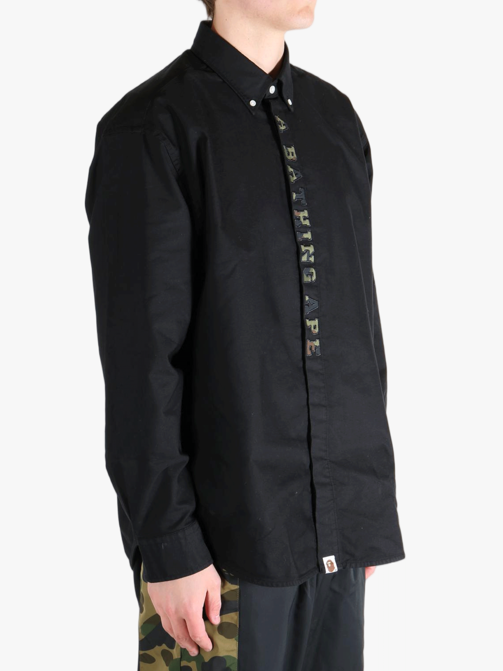 Black shirt worn by a person, showing the shirt's fit