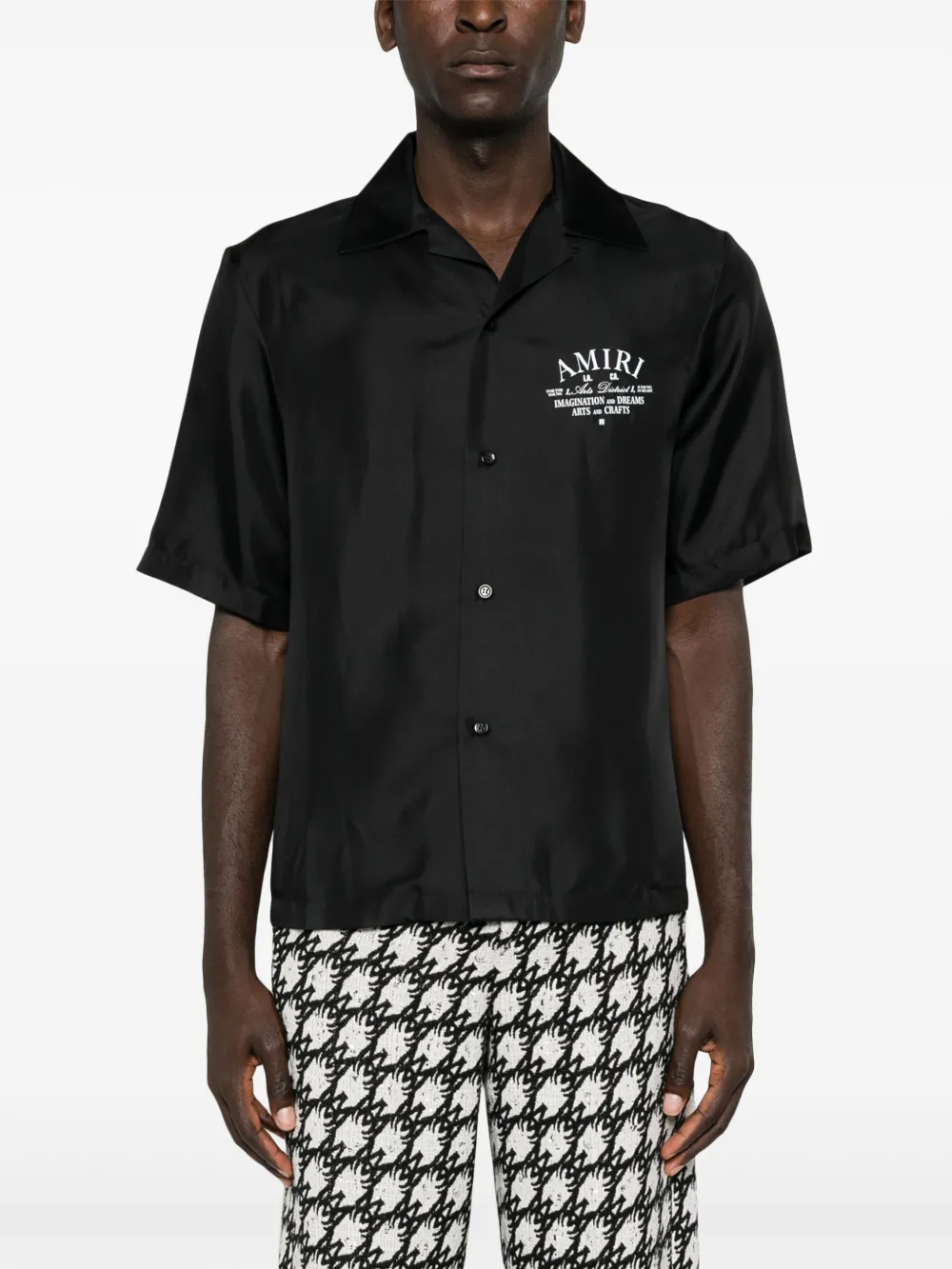 Black shirts worn by a person, showing the shirt's fit