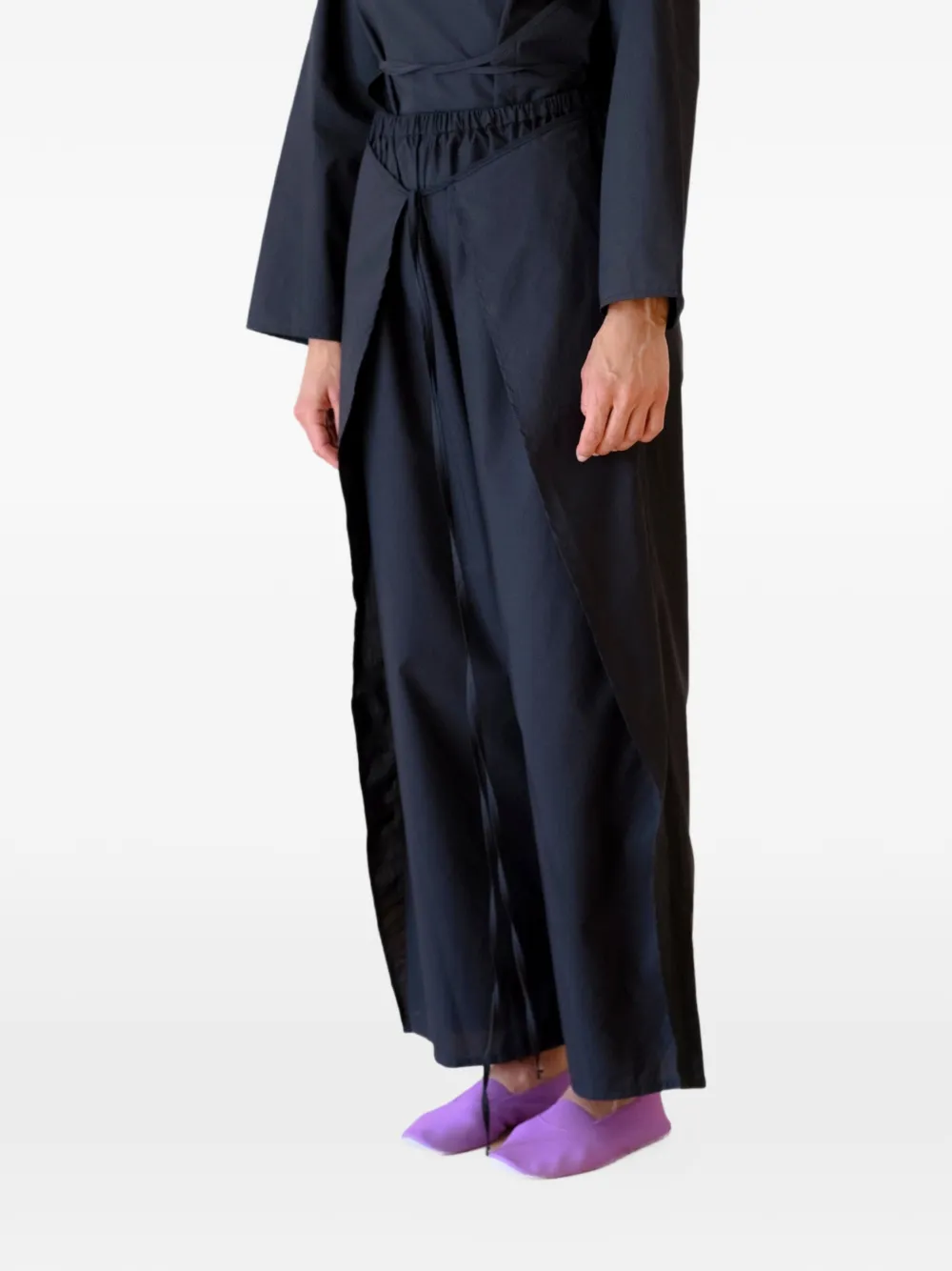 Black pants worn by a person, showing the pants's fit