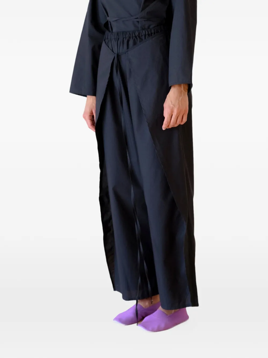Black pants worn by a person, showing the pants's fit