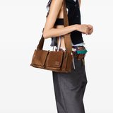 Brown leather bag worn by a person, showing the bag fit