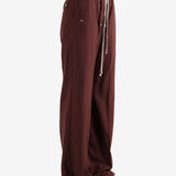 Burgundy pants worn by a person, showing the pants fit