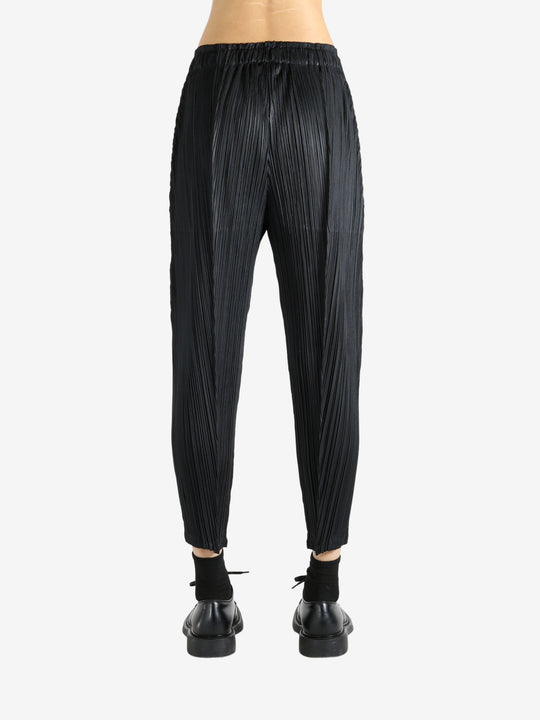 Black pants worn by a person, showing the pants' fit