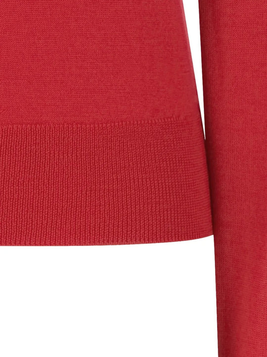 Close up of red knitwear, showing texture of the wool fabric