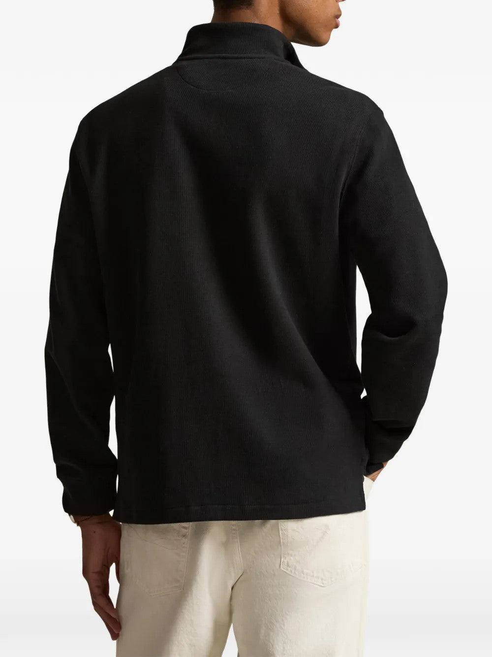 Black knitwear worn by a person, showing the knitwear fit