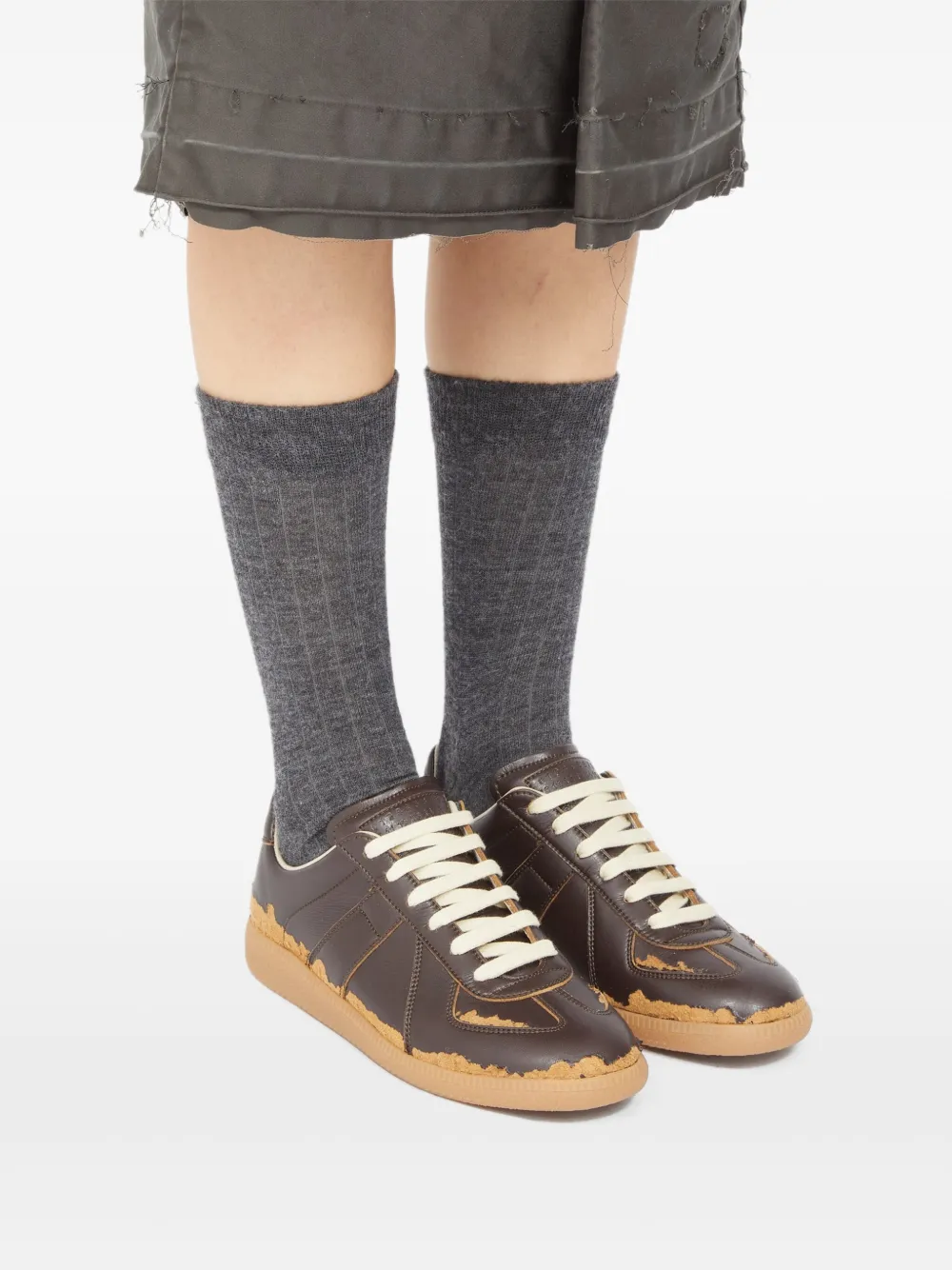 Brown sneakers worn by a person, showing the sneakers' fit