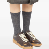 Brown sneakers worn by a person, showing the sneakers' fit