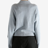 Blue knitwear worn by a person, showing the knitwear's fit