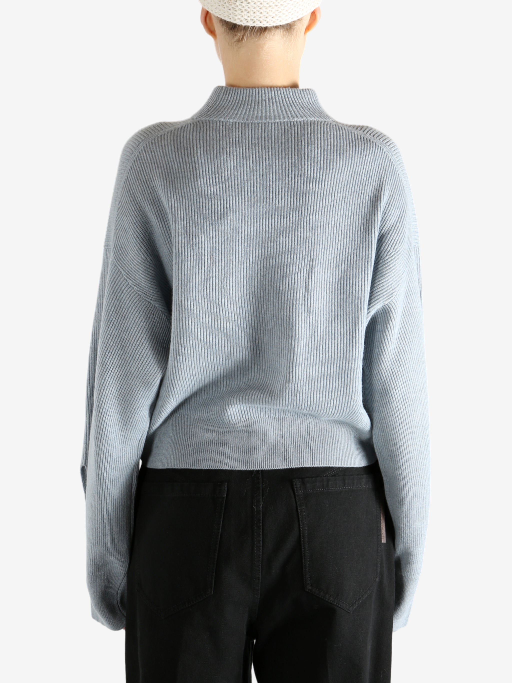 Blue knitwear worn by a person, showing the knitwear's fit