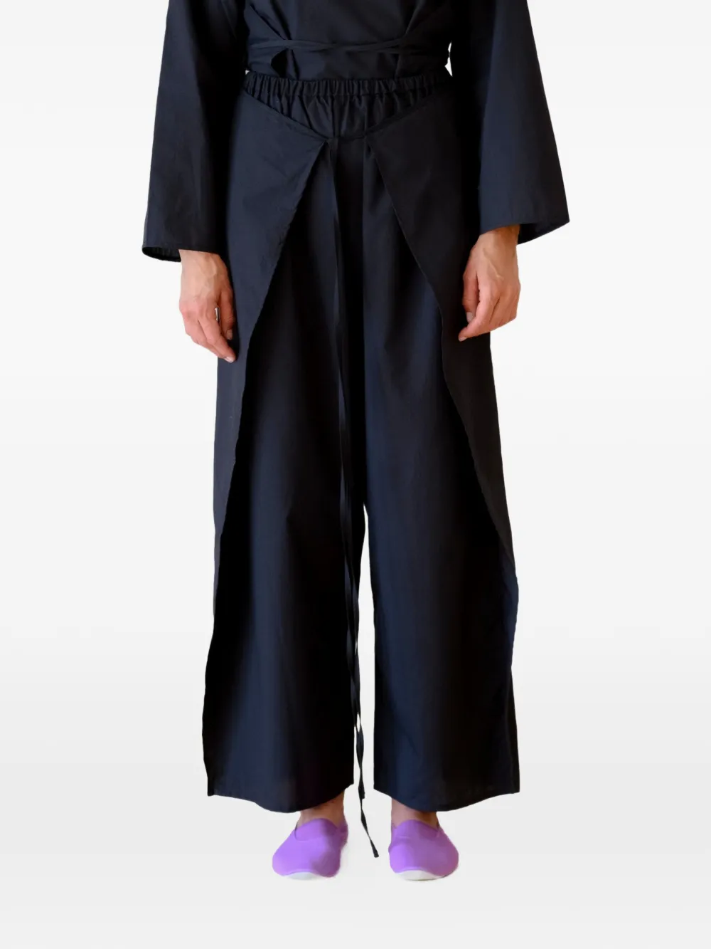 Black pants worn by a person, showing the pants's fit
