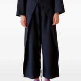 Black pants worn by a person, showing the pants's fit
