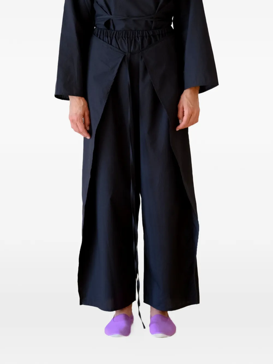 Black pants worn by a person, showing the pants's fit
