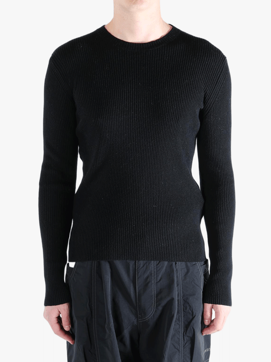 Black sweater worn by a person, showing the sweater fit