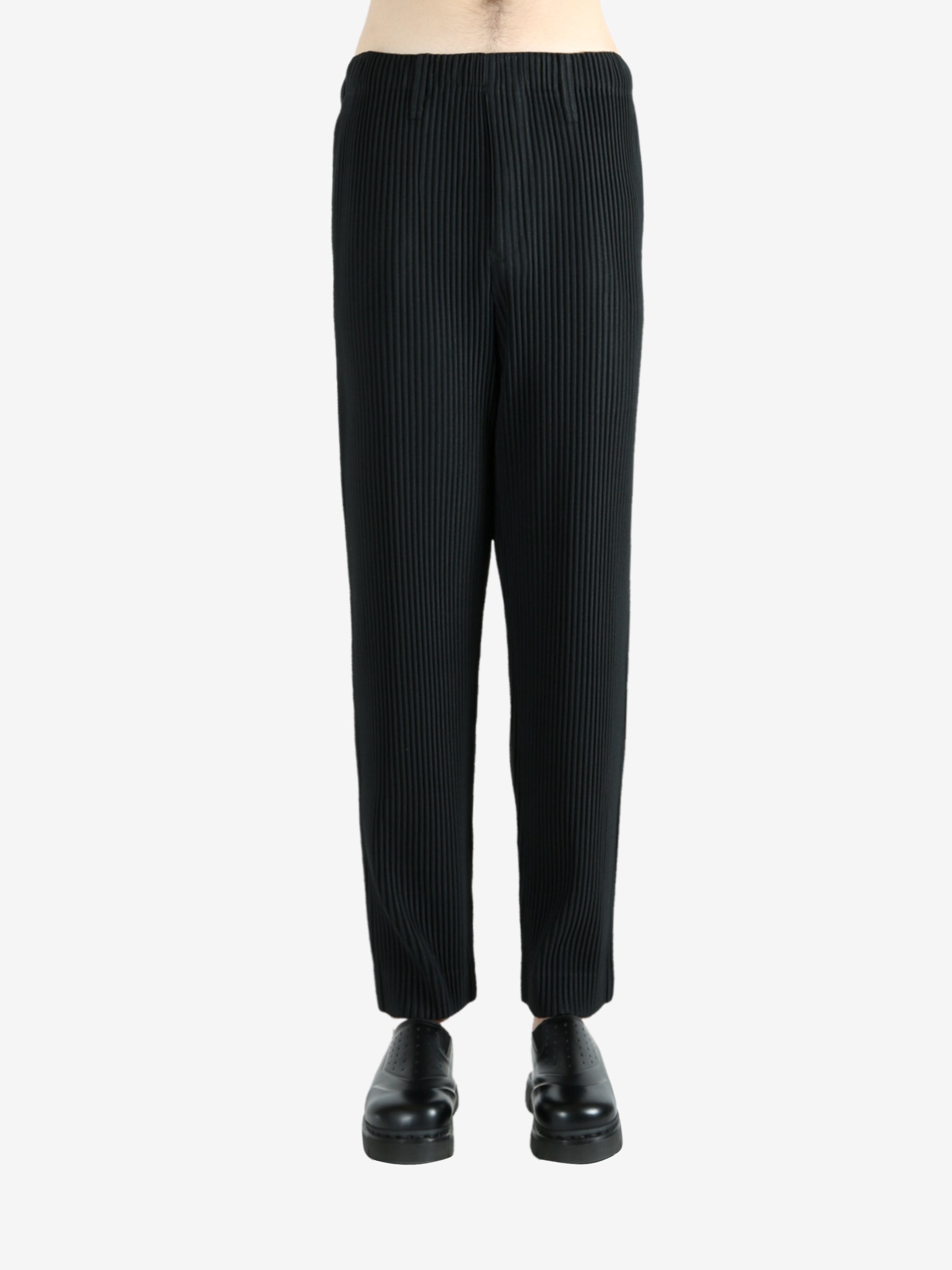 Black pants worn by a person, showing the pants's fit