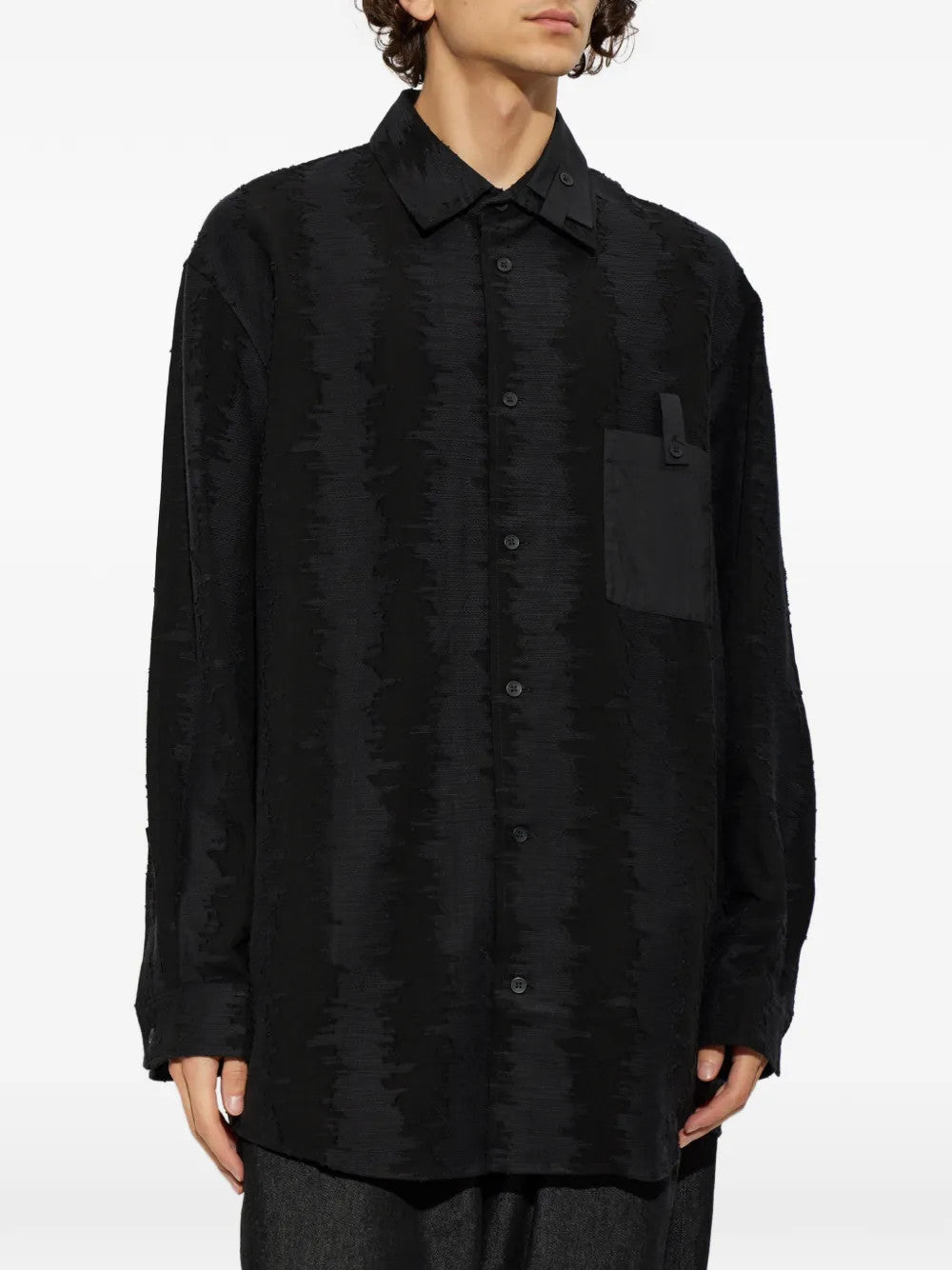 Black shirt worn by a person, showing the shirt fit