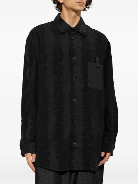 Black shirt worn by a person, showing the shirt fit