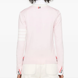 Pink knitwear worn by a person, showing the knitwear's fit