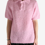 Pink knitwear worn by a person, showing the knitwear's fit