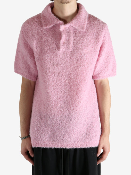 Pink knitwear worn by a person, showing the knitwear's fit